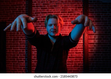 Youth Culture. A Modern Guy With Red Hair And Short Beard Wearing A Casual Sports Suit Is Dancing A Street Dance On A Dark Grunge Background. Hip-hop Culture.