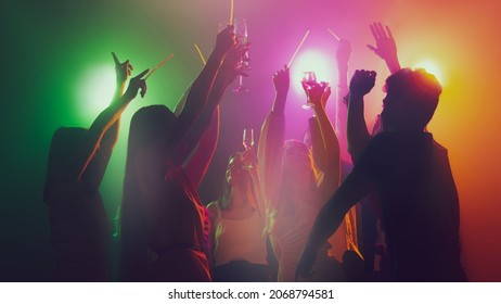 Youth culture, night lifestyle. Vising concert. Group of young, active people at the night club, party dancing in neon lights. Concept of party, fun, holiday, relaxation, meeting Copy space for ad - Powered by Shutterstock