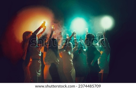 Youth culture, night lifestyle. Vising concert. Group of young, active people at the night club, party dancing in neon lights. Concept of party, fun, holiday, relaxation, meeting Copy space for ad