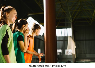 Youth Female Soccer Team. Reserve Players Support Team From Bench. Girls Ready To Play European Football Match. Fan And Reserve Player Watch The Student Sport Match Indoor Gym