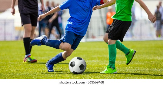 Youth Football Teams Playing Match on Sports Field. Young Boys Running and Kicking Soccer Ball. Football Soccer Duel. Youth Soccer Drill Dribbling