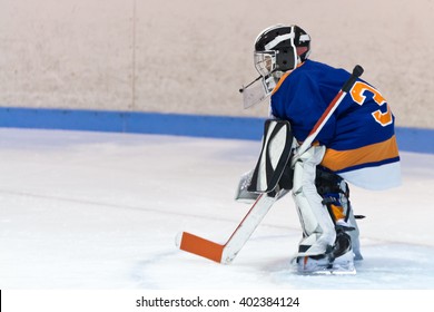 Youth Ice Hockey Goaltender Stands Ready For The Puck During A Game