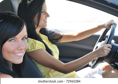 Youth Lifestyle - Two Smiling Friends (women) Driving In Car