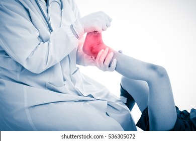 Youth Soccer Player Foot Pain, On White Background. Doctor Checking And Give First Aid At Foot Patient. Photo With Color Increase Blue Skin And Red Spot Indicating Location Of Pain.