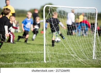 Youth Soccer - This Is A Shot Of A Youth Soccer Team And Their Coaches Playing A Game. Shot With A Shallow Depth Of Field With The Focus Set On The Goal.