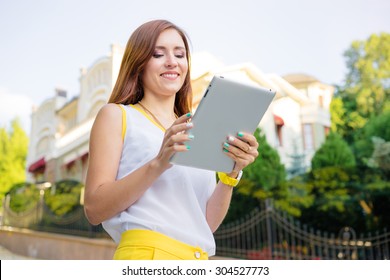 Youth And Technology. Attractive Young Woman Using Tablet Computer Outdoors.