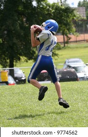 Youth Teen Football Player Catching Football During Game.