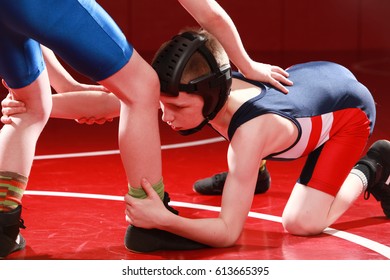 Youth wrestler taking a low single shot on his opponent.