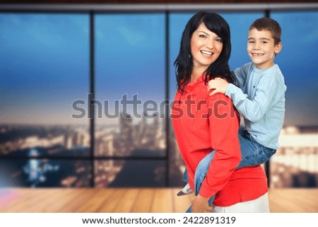 A youthful brunette woman joyfully carries a child on her back, symbolizing love, care, and maternal bonding in nature