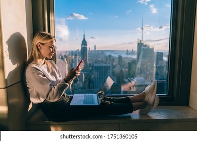 Youthful Millennial Woman Browsing Influence Website During Travel In New York Working With Media Files In High Rise With Panoramic Views On Manhattan Landscape, Skilled Blogger Watching Video