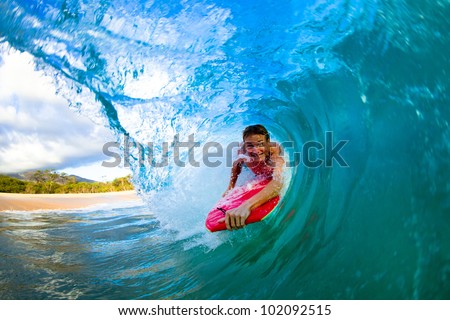 Youthful young man Boogie Boarding Blue Wave