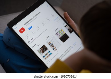 YouTube App Seen On The Screen Of Ipad Which Is In The Hands Of Bored Unrecognisable Child. Concept. Stafford, United Kingdom, May 18, 2021.