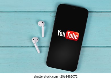 YouTube Mobile Logo App On Screen Smartphone IPhone With AirPods On A Colored Background. YouTube Is A Free Video Sharing Application That Anyone Can Watch. Moscow, Russia -  September 26, 2021