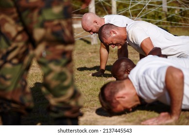 Youve gotta push through the pain. Shot of a group of men doing push-ups at a military bootcamp. - Powered by Shutterstock