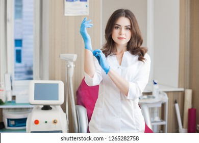 Yoyng beautiful doctor with copy space. Attractive dermatologist cosmetologist at the medical clinic. Beauty salon interior. Woman wearing uniform. - Shutterstock ID 1265282758