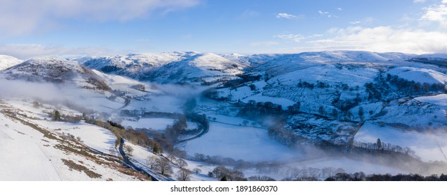Ystwyth valley in Ceredigion, Wales, with mist in the valley bottom and snow on the surrounding woodland and hills
