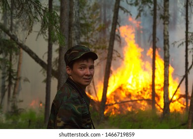 Yuganskiy Nature Reserve, Surgut District, Russia, Siberia - July 20, 2013 - Firefighter With Raging Wildfire In The Background