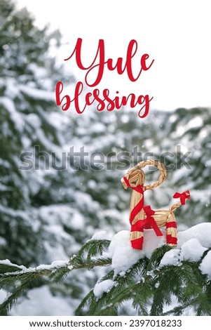 Yule Blessing greeting card. straw Yule Goat on snowy fir tree outdoor. Winter nature background. traditional festive decor, Symbol of Yule holiday. ritual for YuleTide, winter solstice