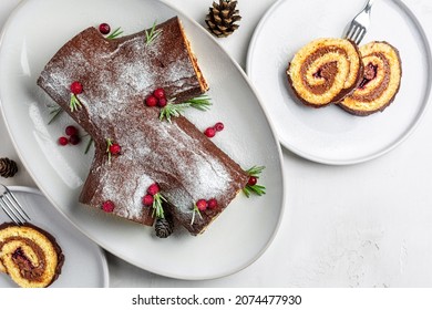 Yule log or Buche de Noel. Traditional Christmas cake. Sponge cake with chocolate cream, ganache, decorated with cranberries. Directly above, copy space. - Shutterstock ID 2074477930