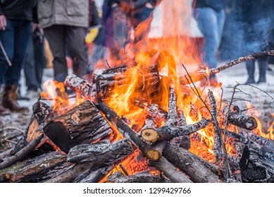 Yule Log Burning Ritual At Church Area With The Faithful In Background
