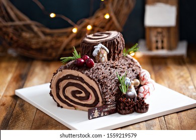 Yule log roll cake for Christmas decorated with chocolate ganache - Shutterstock ID 1559219579