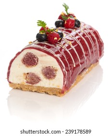 Yule log of white chocolate mousse, stuffed with raspberry puree sponge rolls, glazed with raspberry jelly, garnished with white chocolate, fresh berries, and gold leaf (also know as Buche de Noel)