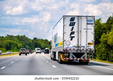 Yulee, USA - May 10, 2018: Swift Transportation truck carrier on interstate multiple lane highway in Florida carrying cargo freight commercial container on rural countryside road
