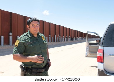 Yuma Sector, Ariz. / US - April 11, 2013: A Customs And Border Protection Agent Standing By A Section Of Landing-mat Fencing In The US-Mexico Border Wall. 1588