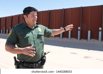 Yuma Sector, Ariz. / US - April 11, 2013: A Customs And Border Protection Agent Standing By A Section Of Landing-mat Fencing In The US-Mexico Border Wall. 1607