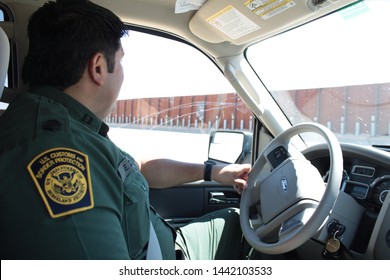 Yuma Sector, Ariz. / US - April 11, 2013: A Customs And Border Protection Agent Drives Past A Section Of Landing-mat Fencing In The US-Mexico Border Wall. 1575