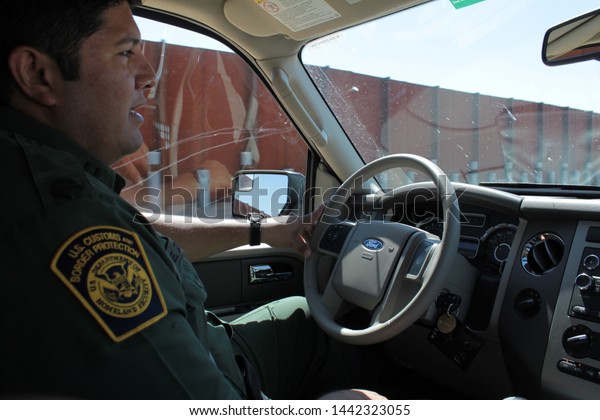 Yuma Sector, Ariz. / US -\
April 11, 2013: A Customs and Border Protection agent drives past a\
section of landing-mat fencing in the US-Mexico border wall.\
1688