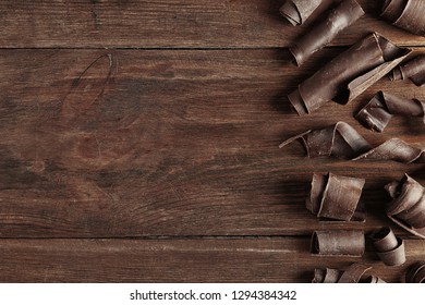 Yummy Chocolate Curls And Space For Text On Wooden Background, Top View