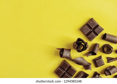 Yummy chocolate curls and space for text on color background, top view