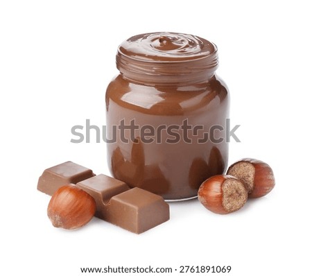Yummy chocolate paste in jar, hazelnuts and piece of chocolate bar isolated on white