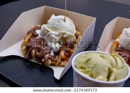 Yummy crispy belgian waffle with chocolate and vanilla ice cream on top