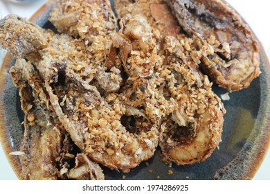 Yummy deep fried cray fish or mantis shrimp  serving on dark plate, top view food.