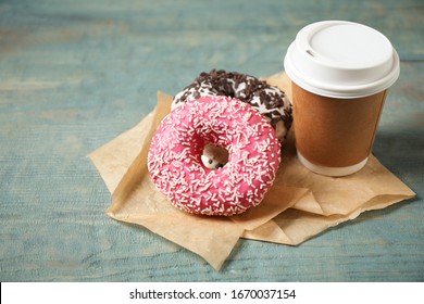 Yummy donuts with sprinkles and paper cup on wooden table - Powered by Shutterstock