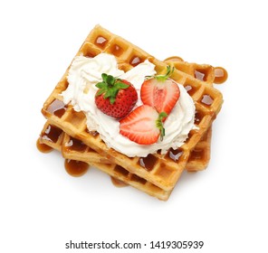 Yummy waffles with whipped cream, strawberries and caramel syrup on white background, top view