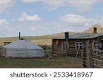 Yurt and old wooden house. Cattlemen