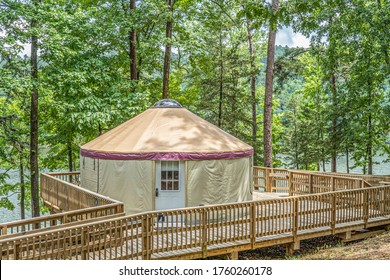 A YURT On A Wooden Deck In A Forest Camp Ground.