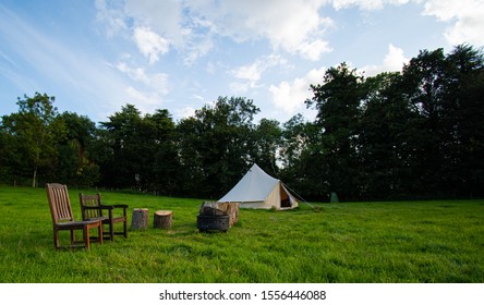 A Yurt, Or Round Tent, With Chairs And Logs Outside On A Glamping Site In The Cotswolds