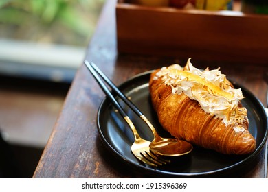 Yuzu Croissant On Black Plates And Cutlery