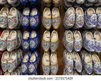 Zaanse Schans, North Holland, Netherlands- May 21, 2022: Traditional wooden handmade Dutch clogs pairs are hanging on wall in small local souvenir store. Background texture, pattern.