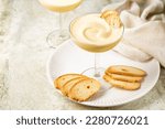 Zabaione or sabayon, or advocaat in a champagne coupe, alcoholic creamy drink  or dessert. Cream made with egg yolks, sugar, and a sweet wine Marsala or liqueur. Baicoli biscuits.  