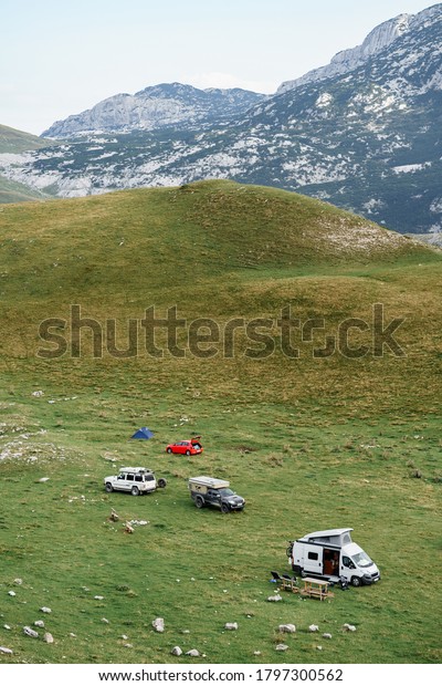 Zabljak, Montenegro - 23 july 2020: Tourists set up\
a car camp in the mountains, on the green grass. Montenegro,\
Durmitor National\
Park.