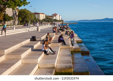 Zadar, Croatia - 07 October, 2010: People Relax At The Sea Organ At Sunset, Experimental Musical Instrument, Which Plays Music Generated By The Motion Of Sea Waves Of The Adriatic Sea, City Landmark.