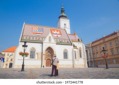 Zagreb, Croatia - October 7 2018: An Elderly Tourist Couple Visit The Historic Church Of St Mark In St Mark's Square In Old Town Zagreb, Croatia.