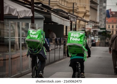 ZAGREB, CROATIA - SEPTEMBER 19, 2021: Bolt Food Delivery Man Cycling In Zagreb With A Bag With Its Logo. Bolt Food Is A Mobility Company App Specialized In Food Delivery.



