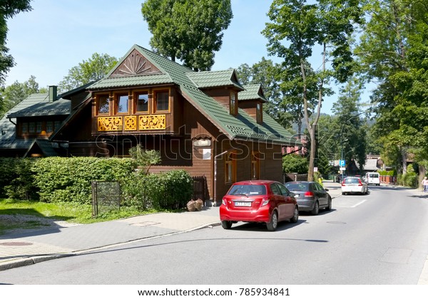 Zakopane, Poland - August 18, 2017: Wooden\
building is covered with a sloping roof and can be seen next to the\
street. This house, named Villa Dabrowa, dates back to the end of\
the nineteenth\
century.