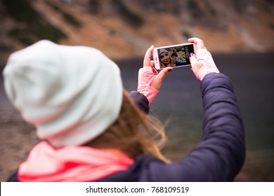 ZAKOPANE, POLAND DECEMBER 02, 2017: Girl Taking Selfie Photo In A Mountains Using IPhone 7 Rose Gold Color